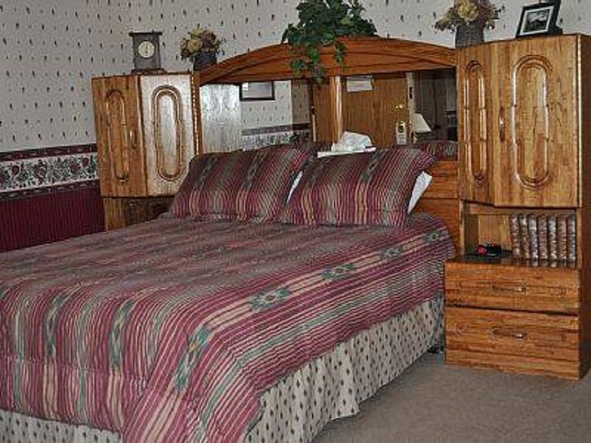 Bedroom with striped bedding, wooden headboard, and floral decor accents