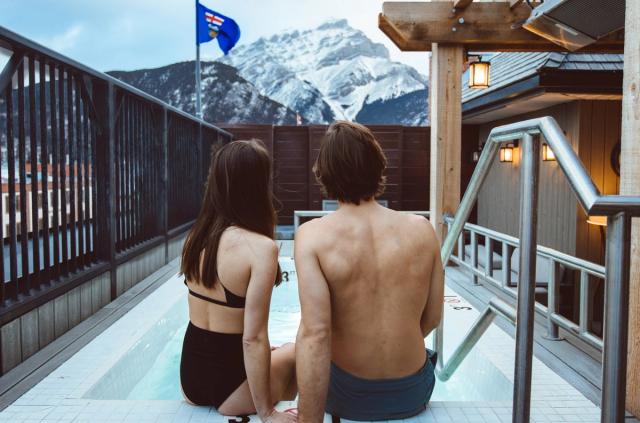 A couple enjoying the outdoor pool at the Mount Royal Hotel in Banff.