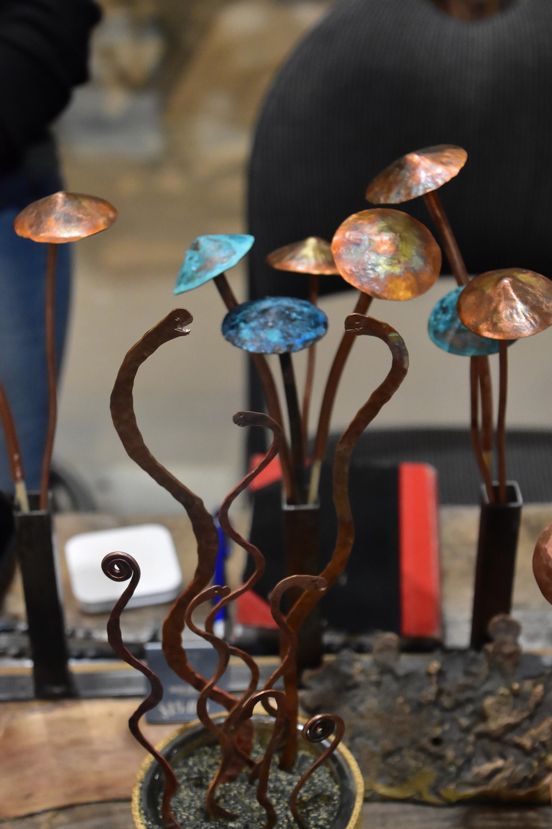 Colorful metal mushroom sculptures arranged on a display table.