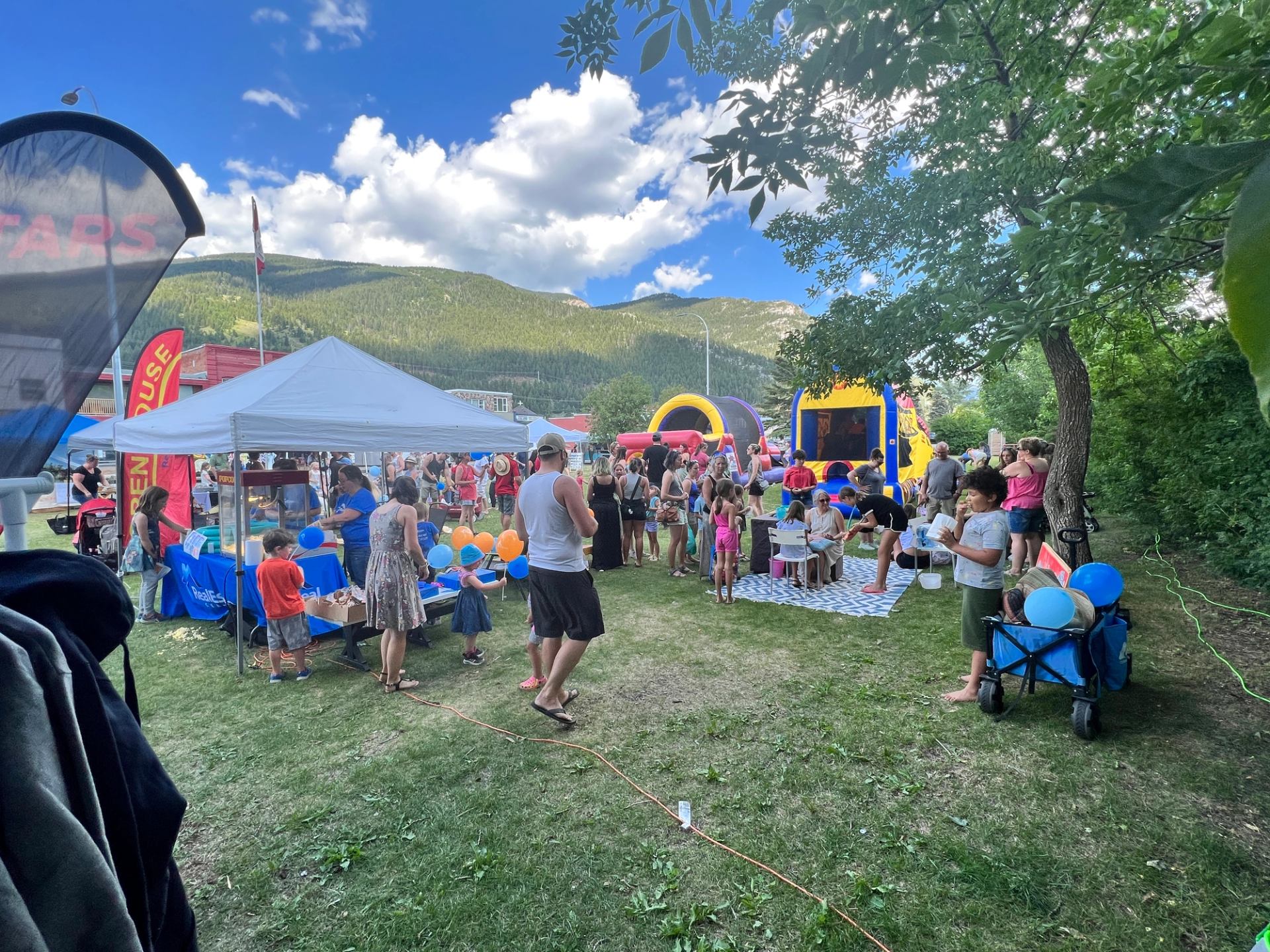 Crowds exploring vendor tents and activities at the outdoor market