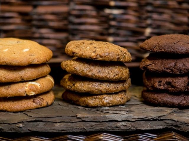 Stacks of assorted cookies on a rustic slate at Wild Flour Bakery.