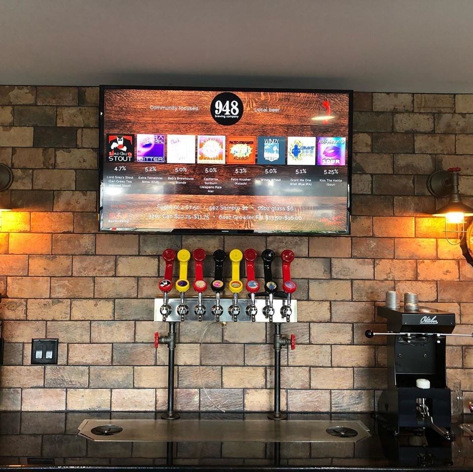 Beer taps at the brewery with a large screen TV