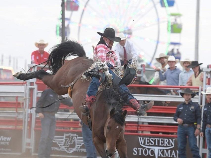 A girl riding a bucking horse