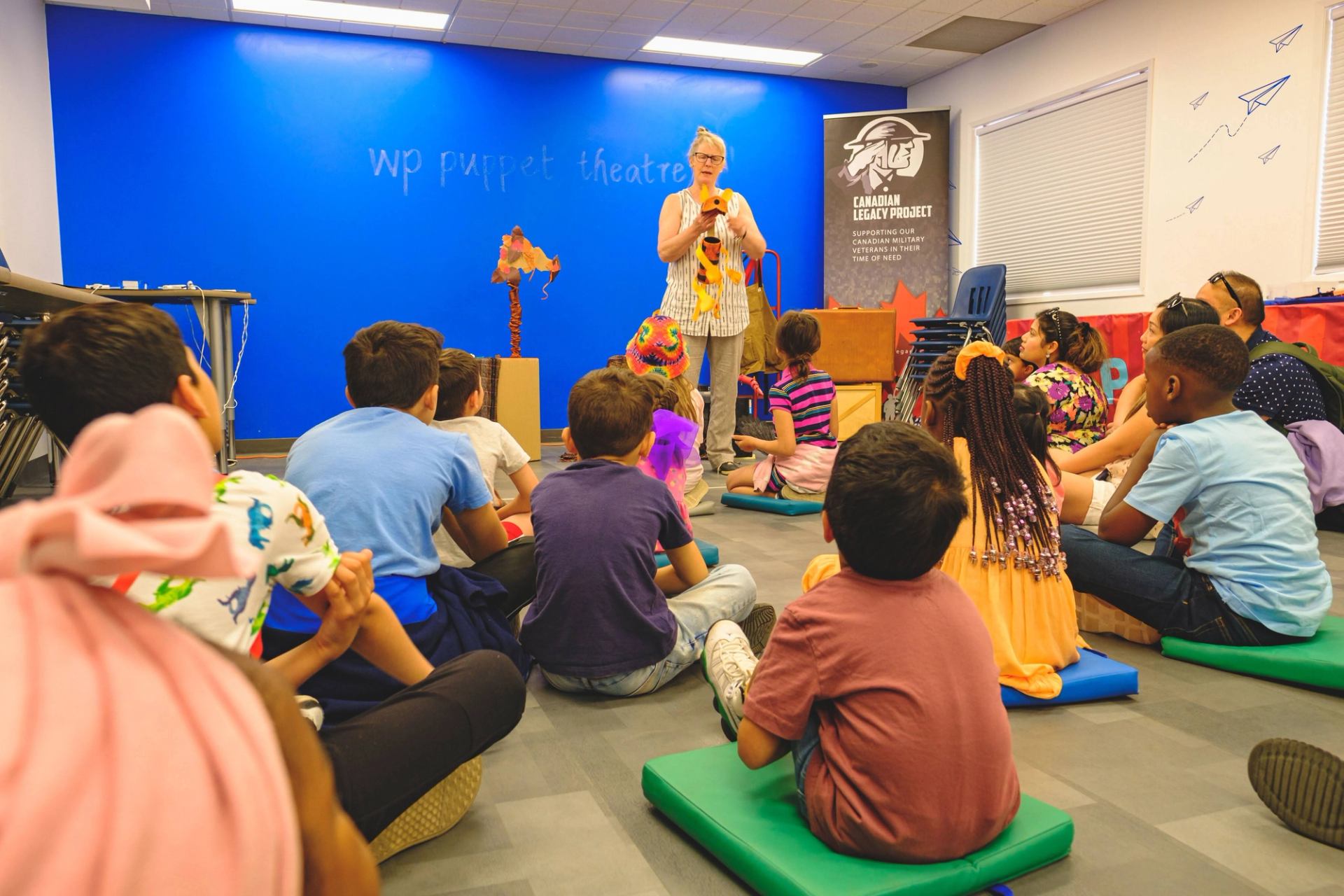 A group of children enjoy the puppet show