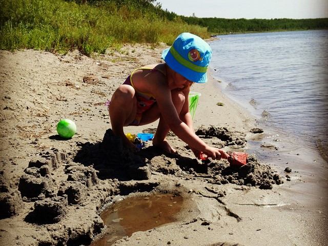 A child making sandcastles in the sand on the beach