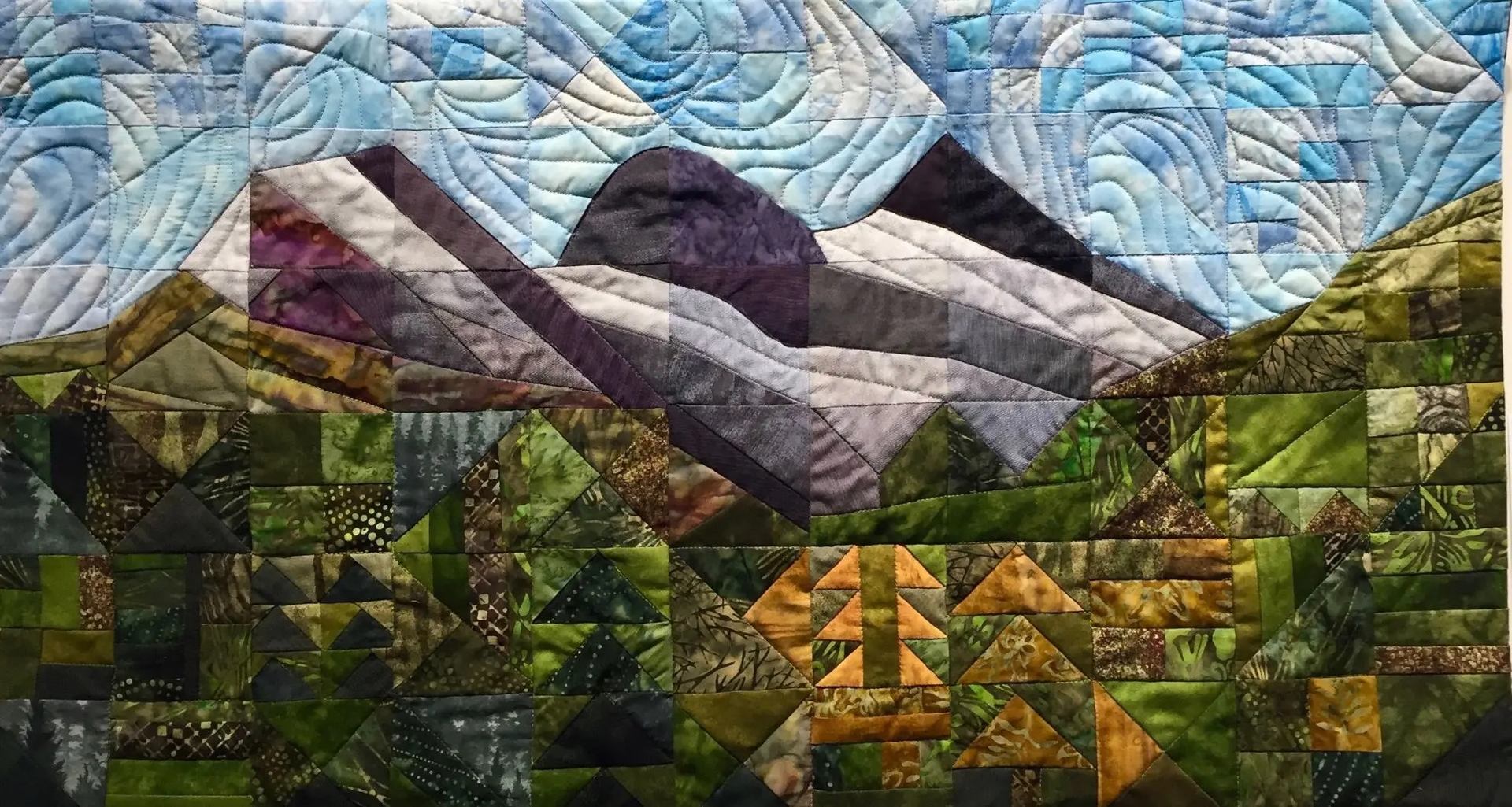 Patchwork quilt landscape with green hills, purple mountains and swirling blue sky patterns.