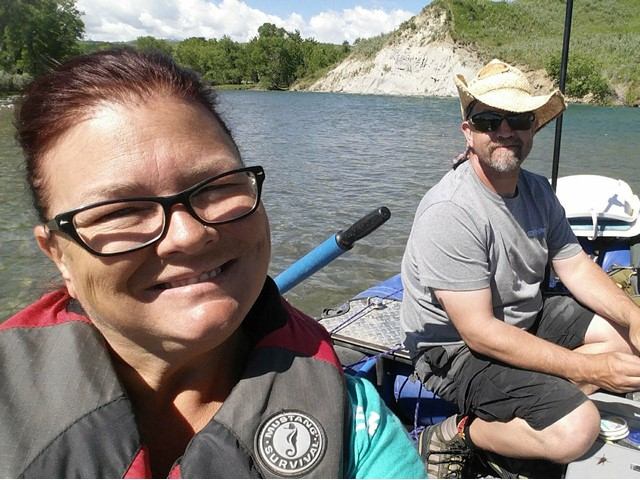Smiling couple on a boat enjoying a sunny day on the river.