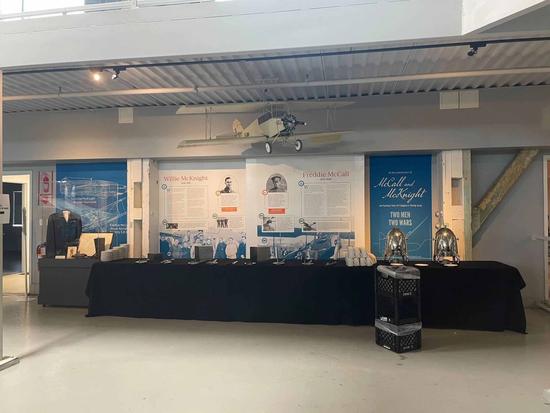 Indoor exhibit at Flight Museum Calgary with a mounted biplane and display panels.