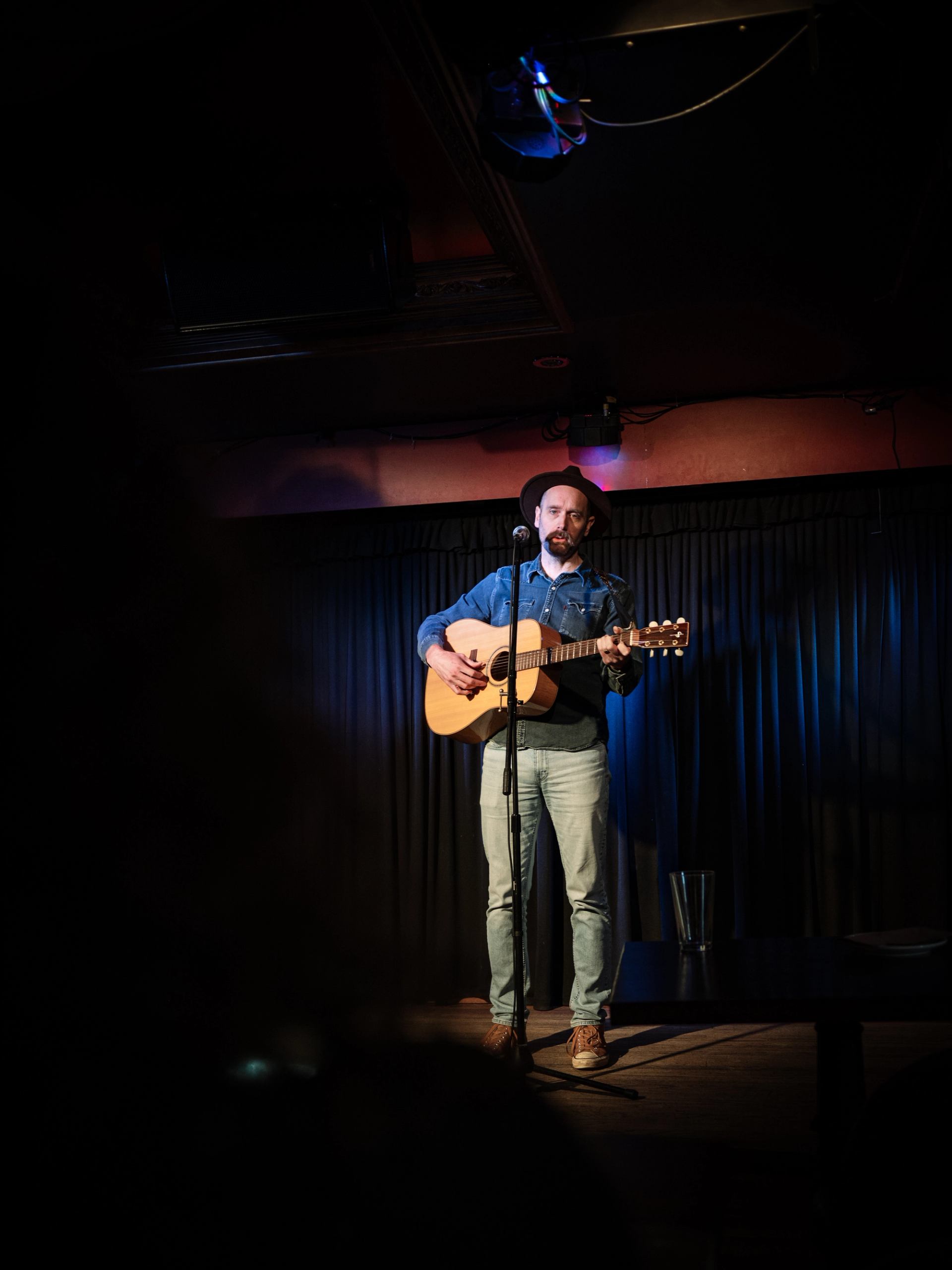 Music in the Badlands showcases a solo acoustic musician under stage lighting.