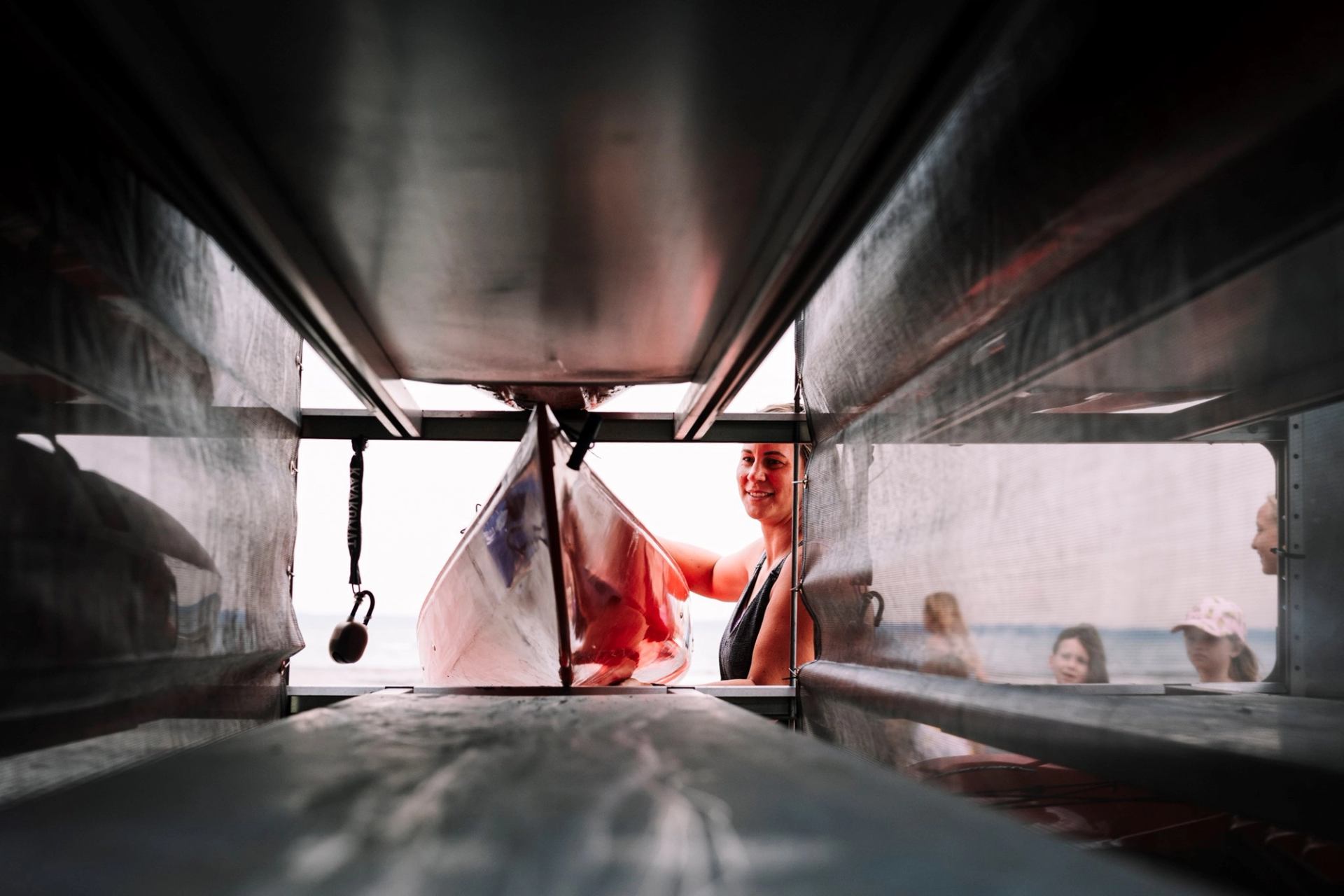 A person pulling out a kayak from the storage shed.