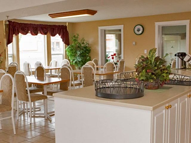 Breakfast area with tables, chairs, and warm decor at Western Budget Motel.