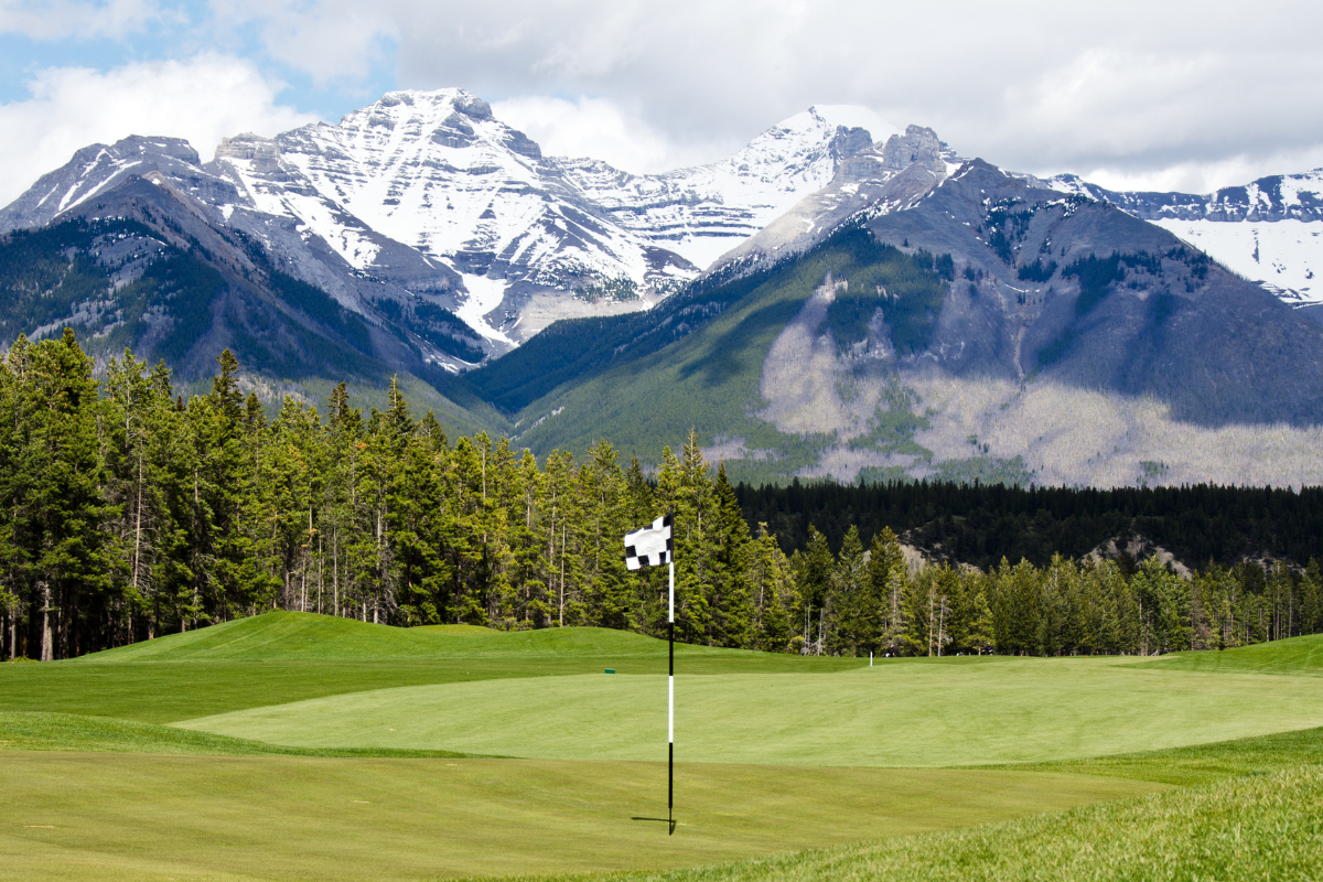 A golf course with the Three Sisters in the background