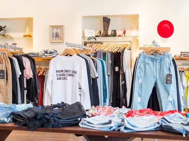 Clothing rack display with T-shirts and jeans inside The Bamboo Ballroom store in Edmonton.