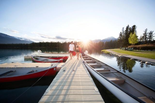 Couple walking on the dock at the Fairmont Jasper Park Lodge.