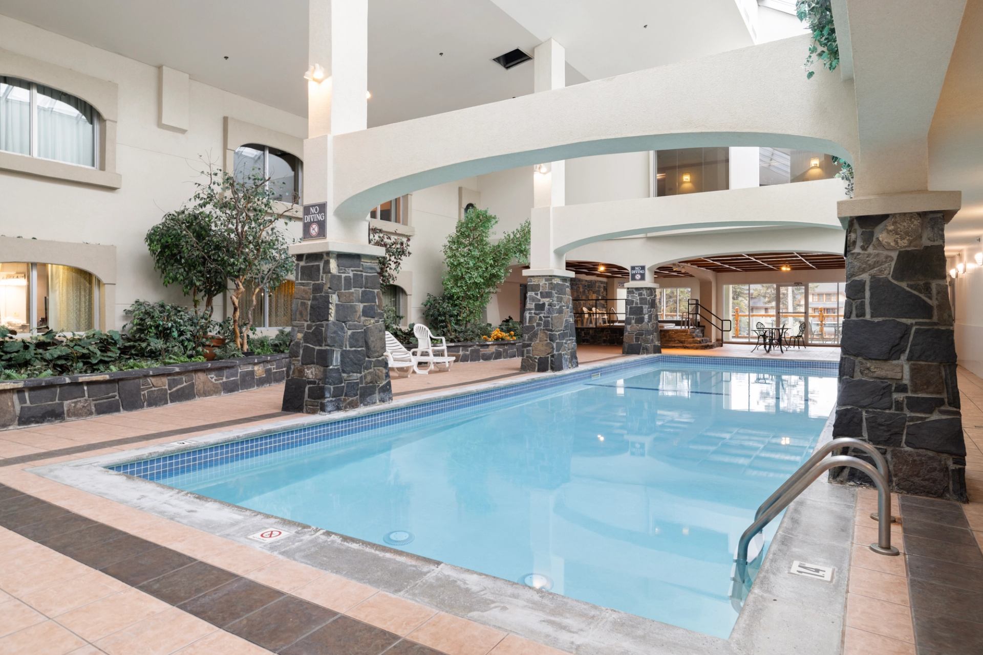Indoor pool with stone pillars and seating area at The Rundlestone Lodge.