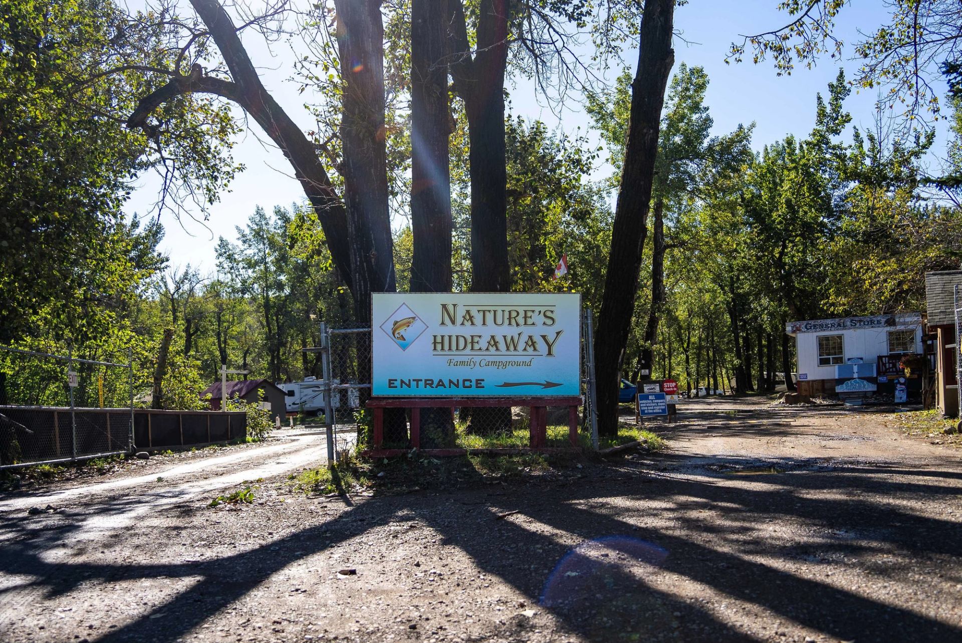 Sign for "Nature's Hideaway Family Campground" with a road leading to the entrance.