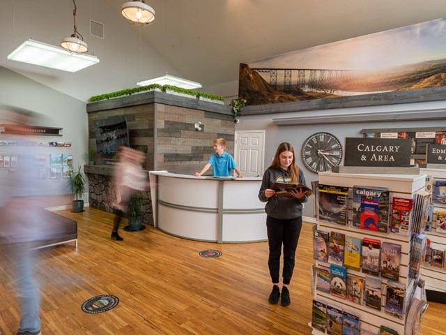 Women reading brochures while people walk around in the background.