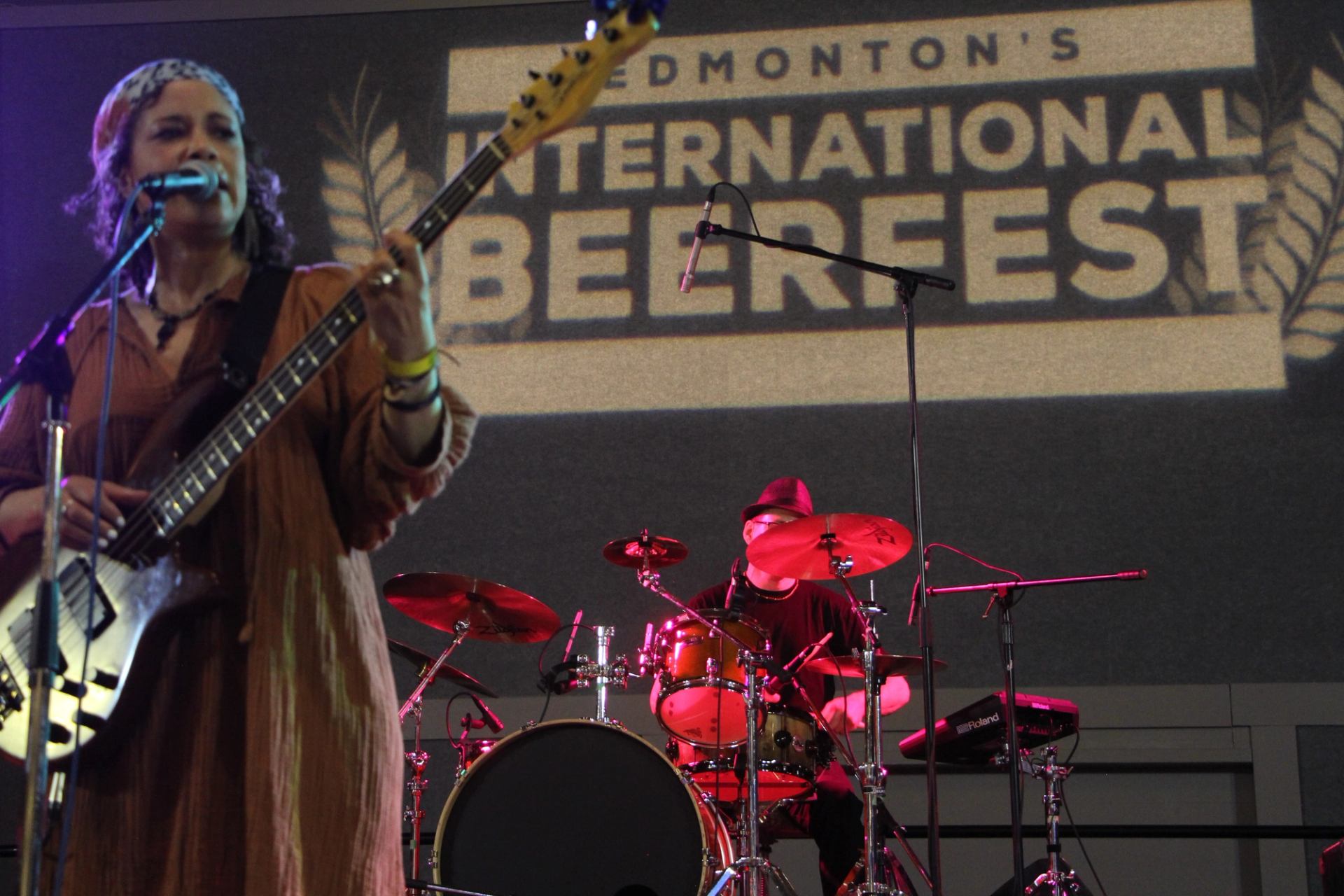 Bassist sings into microphone as drummer plays onstage at Edmonton’s International Beerfest.