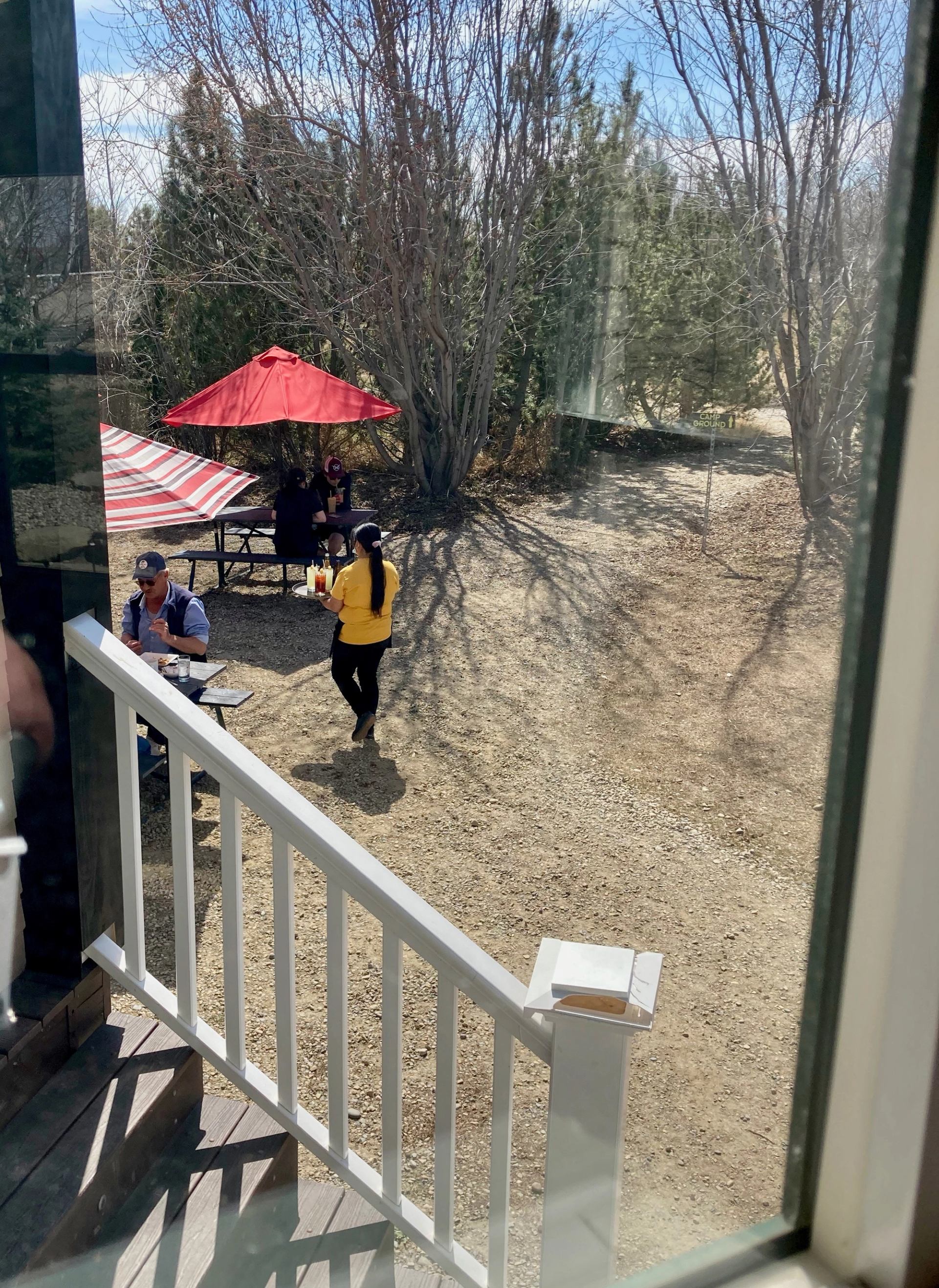 Outdoor patio at The Bergquist Tavern with striped flag, red umbrella, and two people at a table.