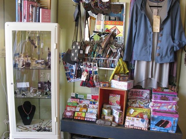 Clothing, purses, jewelry, and gift items arranged in a cozy boutique corner.
