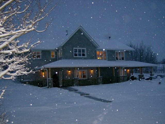 Snowy inn glowing warmly at night.