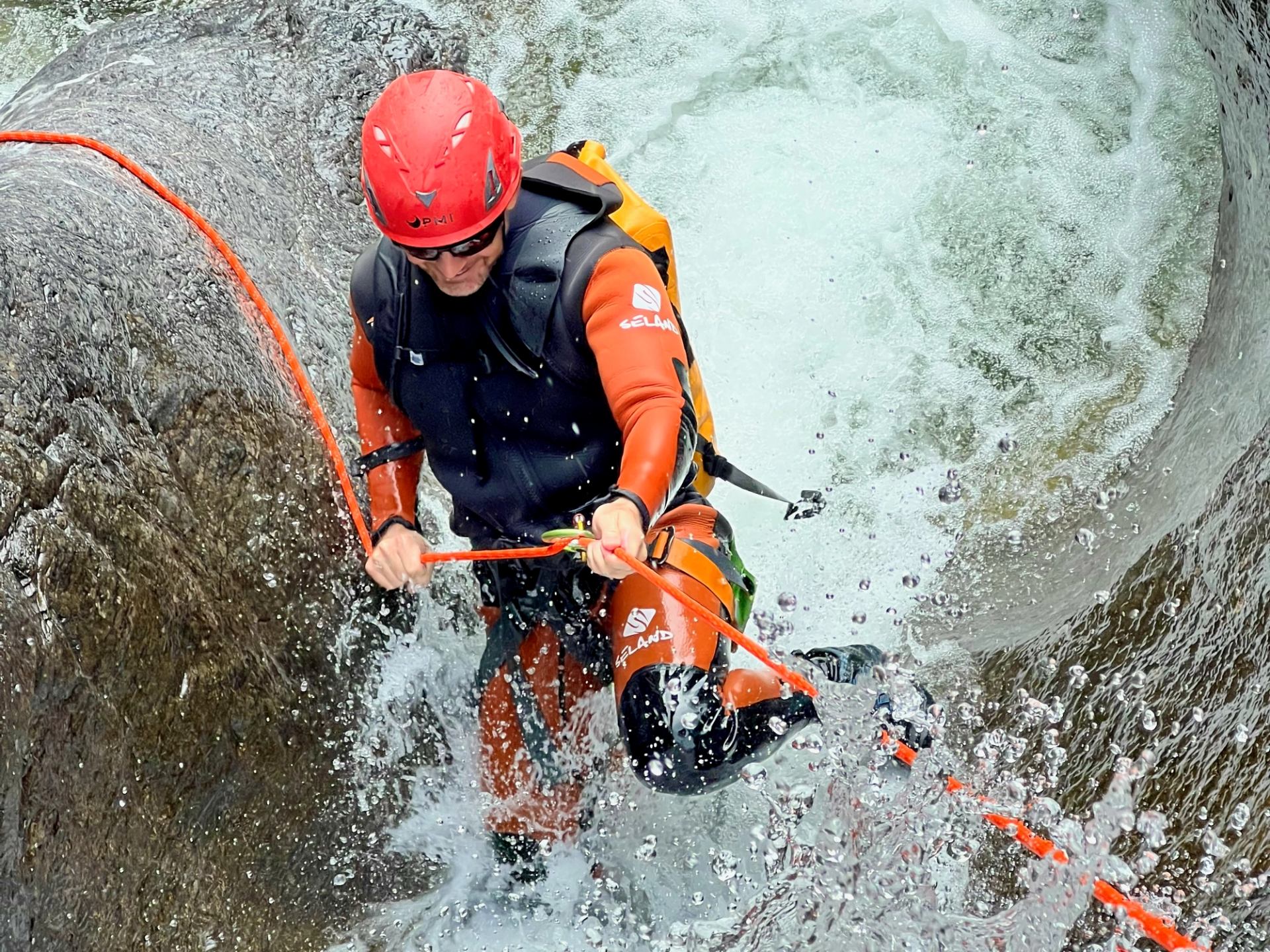 Person rappelling through rushing water in Bow Valley Canyon.