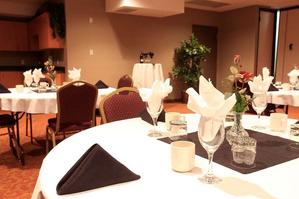 Elegant banquet room with round tables set with folded napkins and glassware.