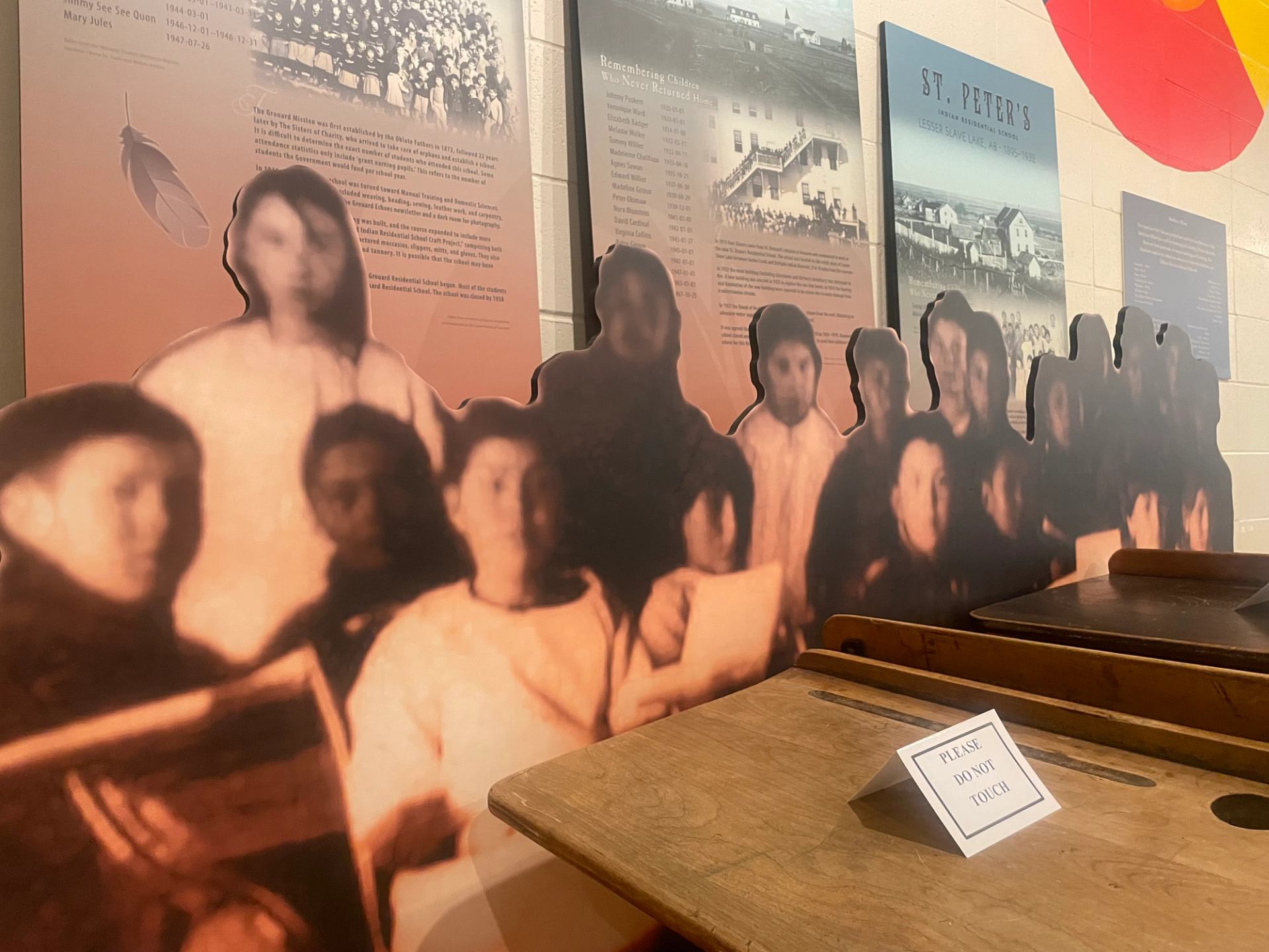 Photo of students from a residential school against interpretive panels about the schools.