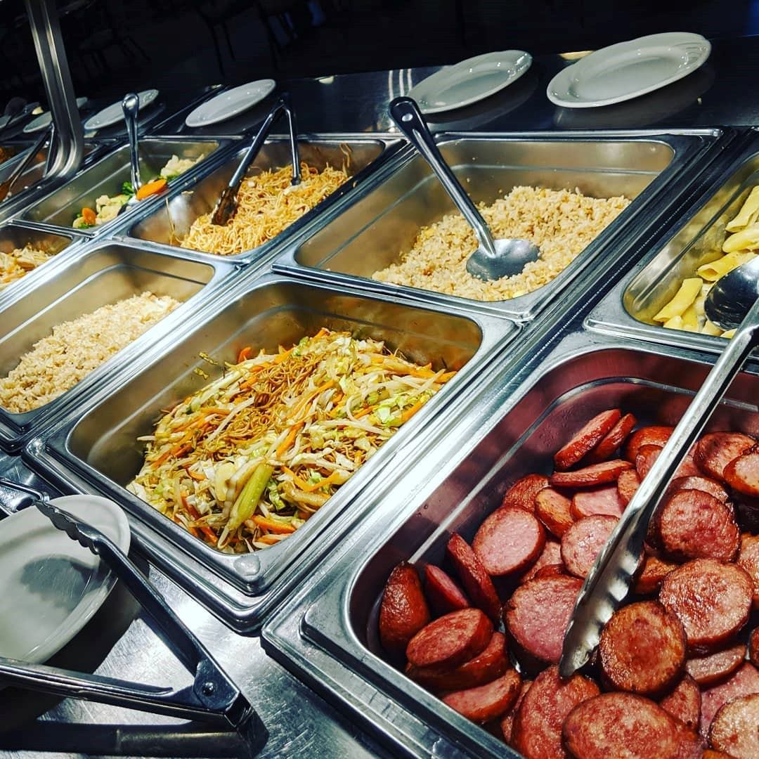 Buffet spread at JB Grill & Bar with meats, veggies, and rice dishes.