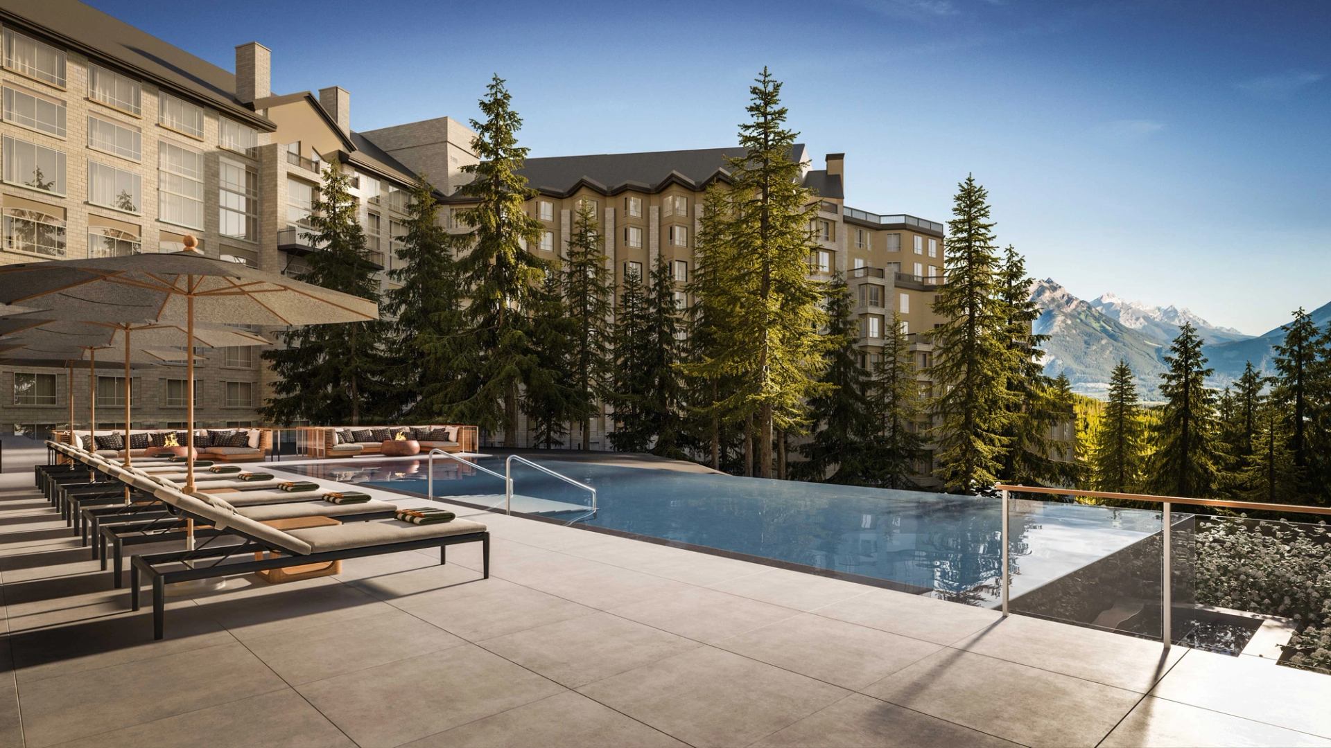 Infinity‑edge outdoor pool and lounge seating overlooking forested slopes and mountain peaks at Rimrock Banff.
