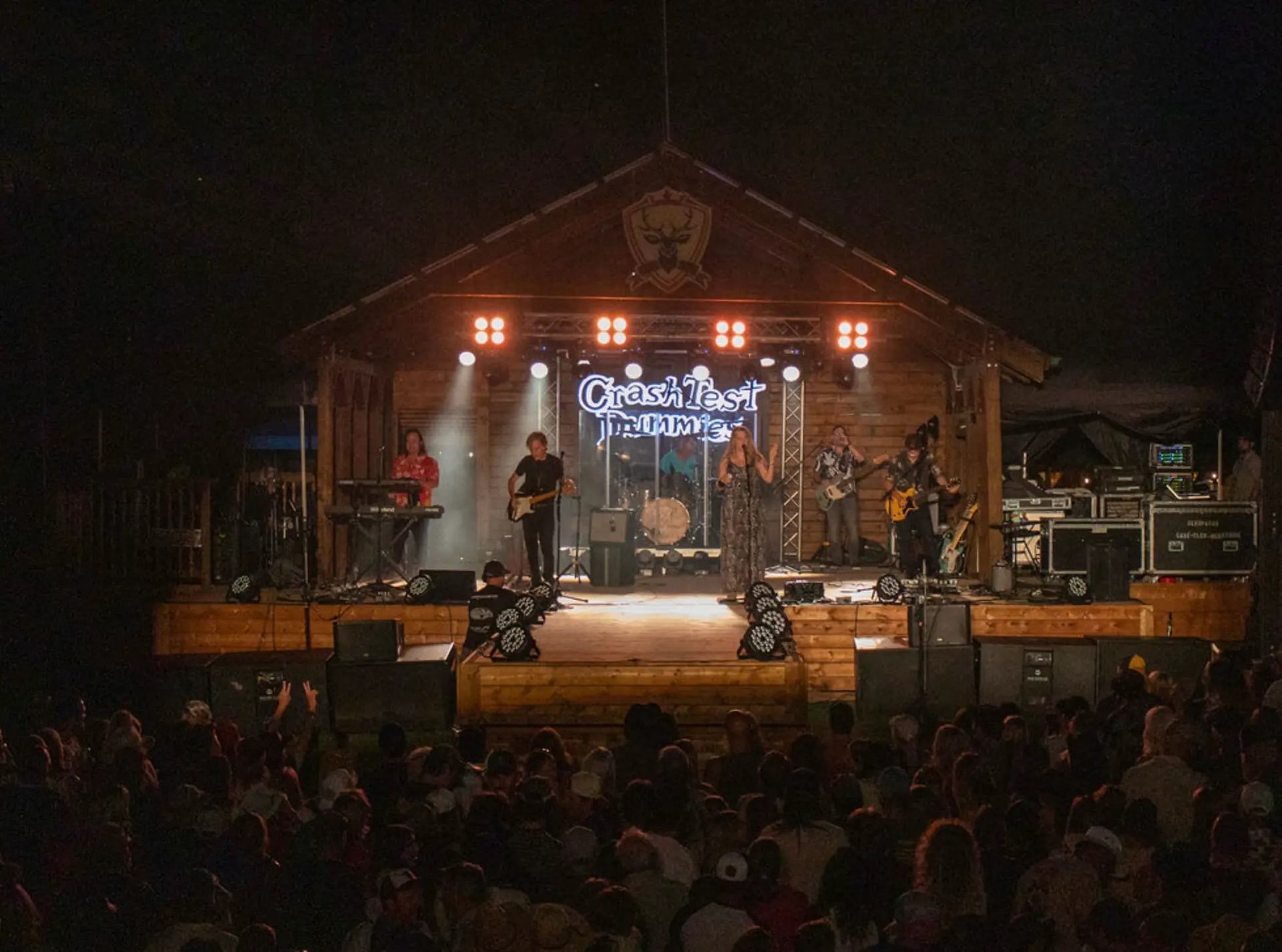 Crash Test Dummies performing on a lit outdoor stage at night with a large crowd watching.
