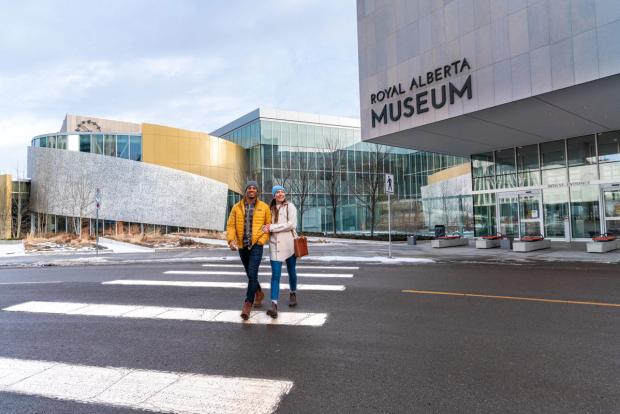 A couple walking in front of the exterior of the Royal Alberta Museum in Edmonton.