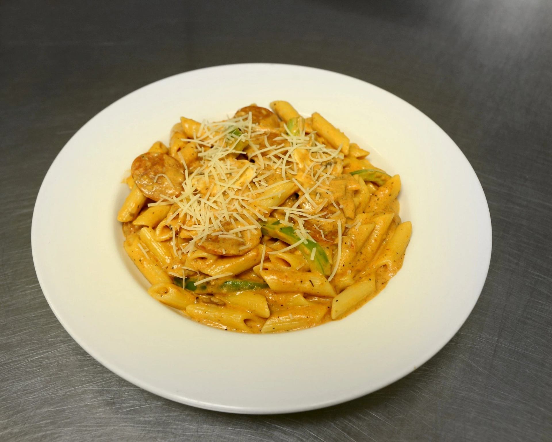 Penne pasta in creamy sauce with cheese and herbs at Piccolos Pizza & Pasta.