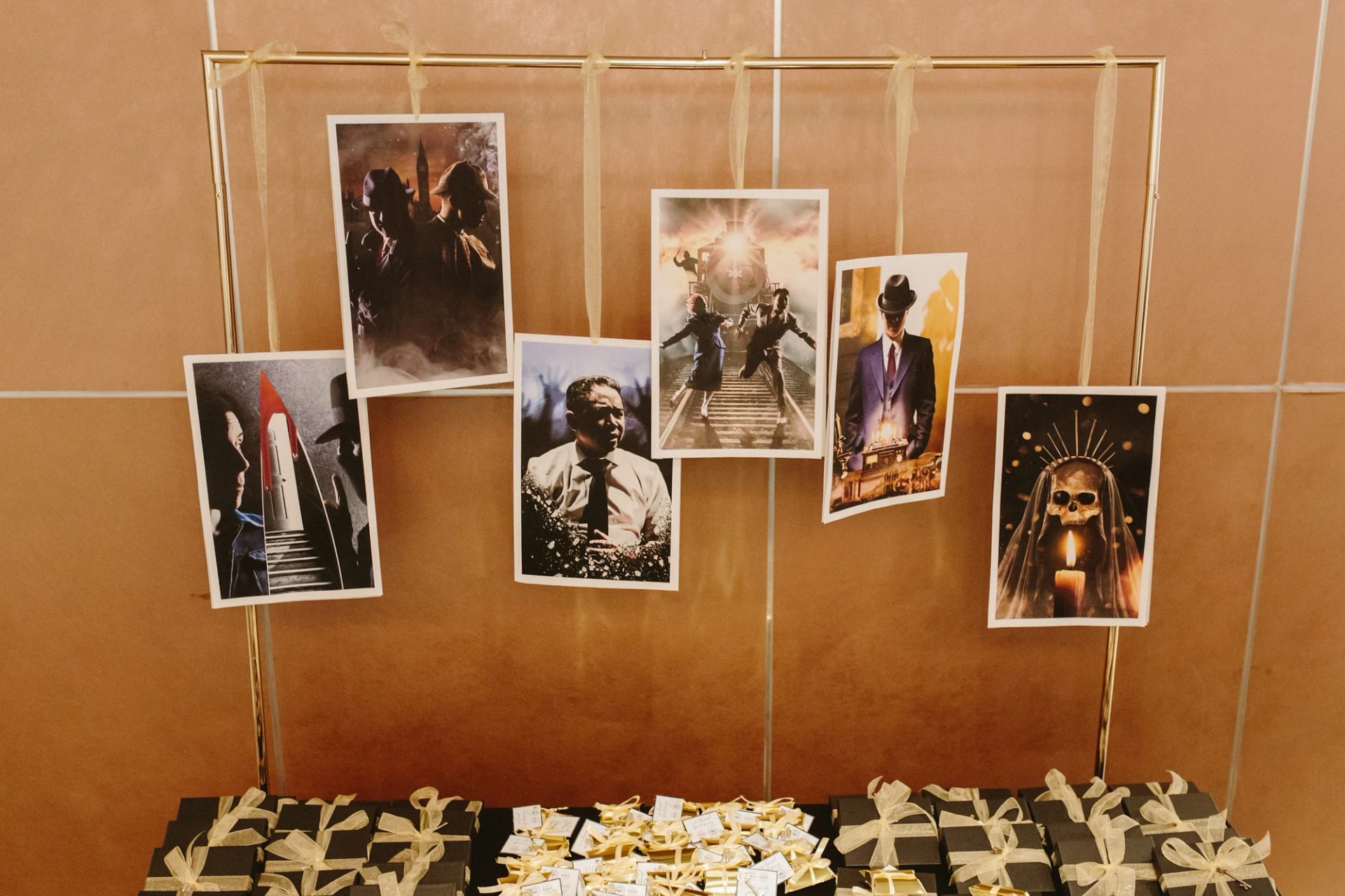 Photo display with dramatic movie-style posters hanging above gift boxes with ribbons.