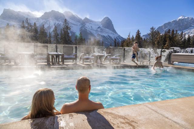 Family enjoying the outdoor pool at the Malcom Hotel in Canmore.