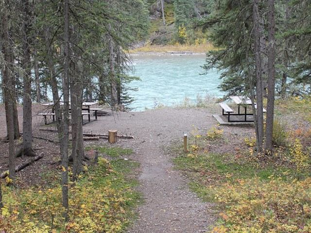 Two picnic tables by the lake