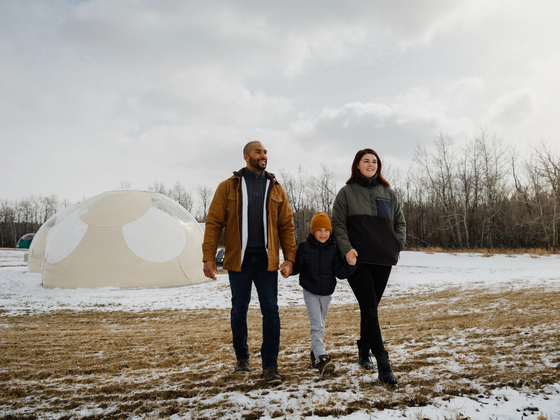 Family walking past snow-covered domes.