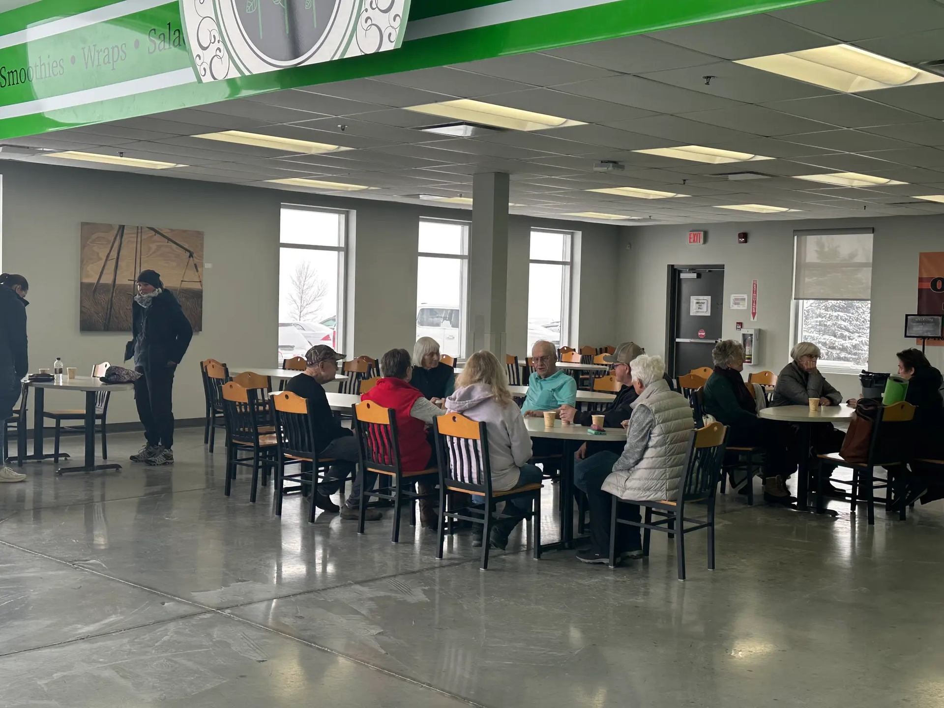 People seated at tables in a bright, modern event area at Regional Field House.