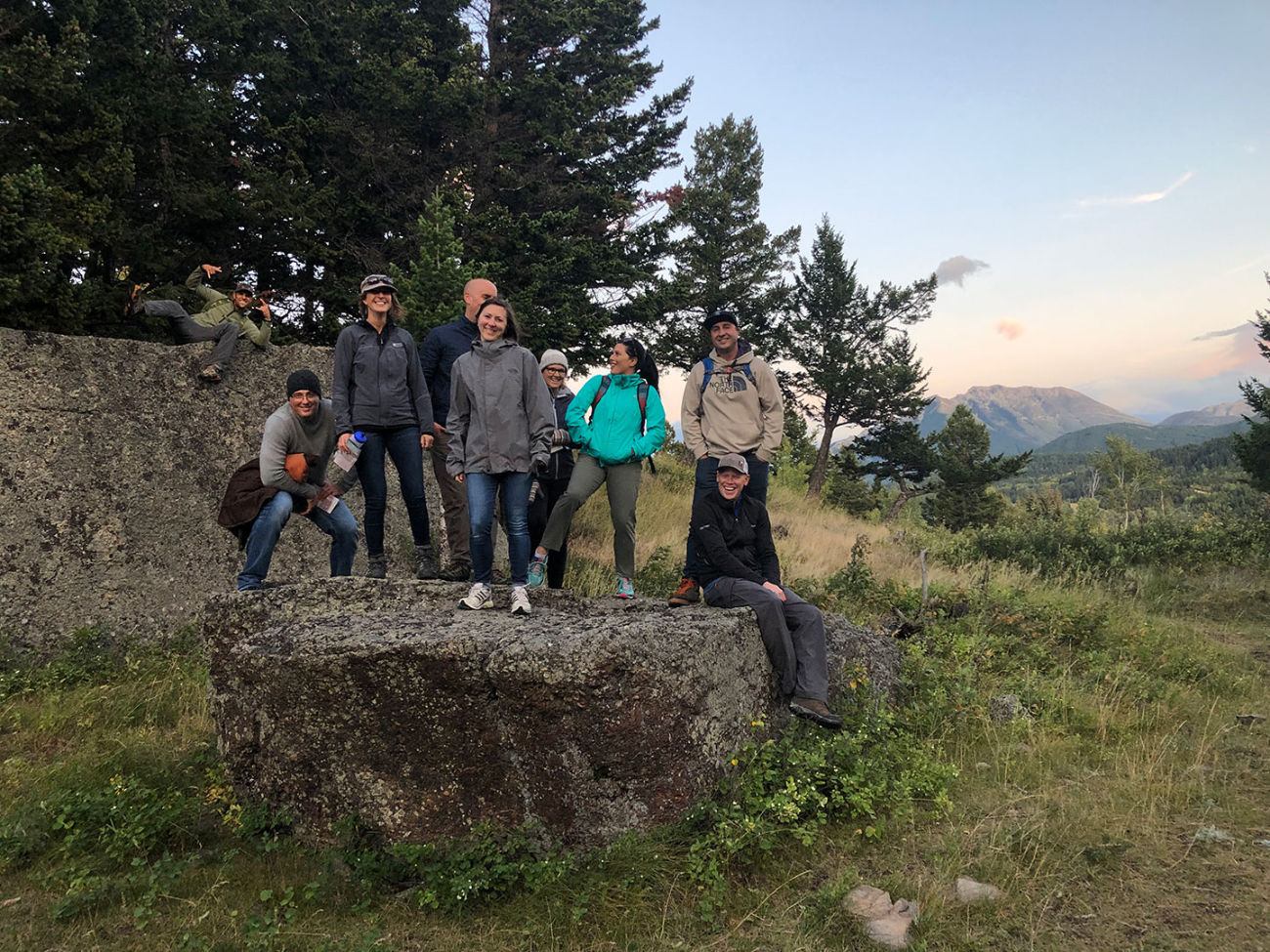 Hiking group standing on large rocks with mountain views.