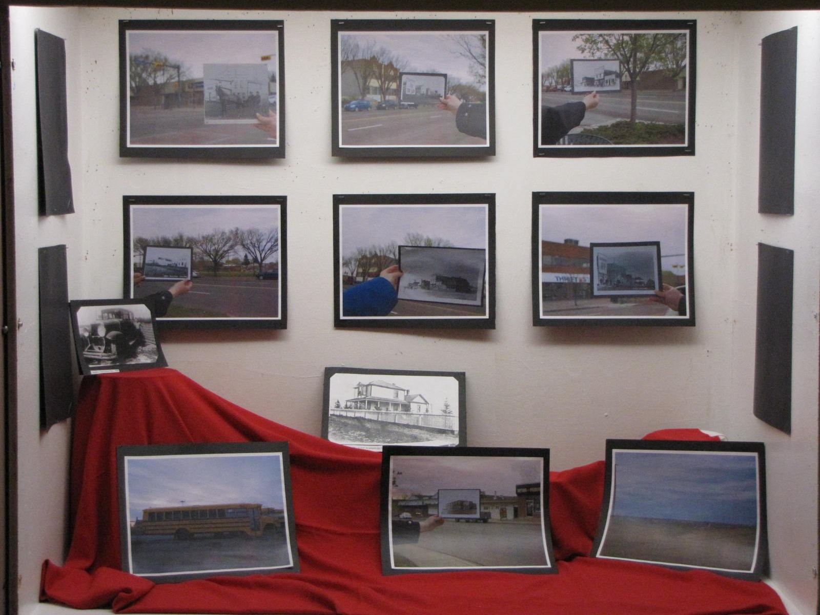 Museum exhibit featuring framed historical photographs displayed on a wall and stand.