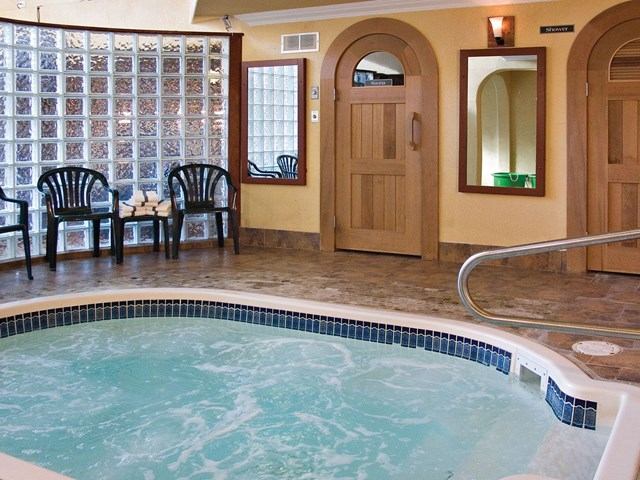 Indoor hot tub area with chairs, mirrors, and a relaxing spa atmosphere.