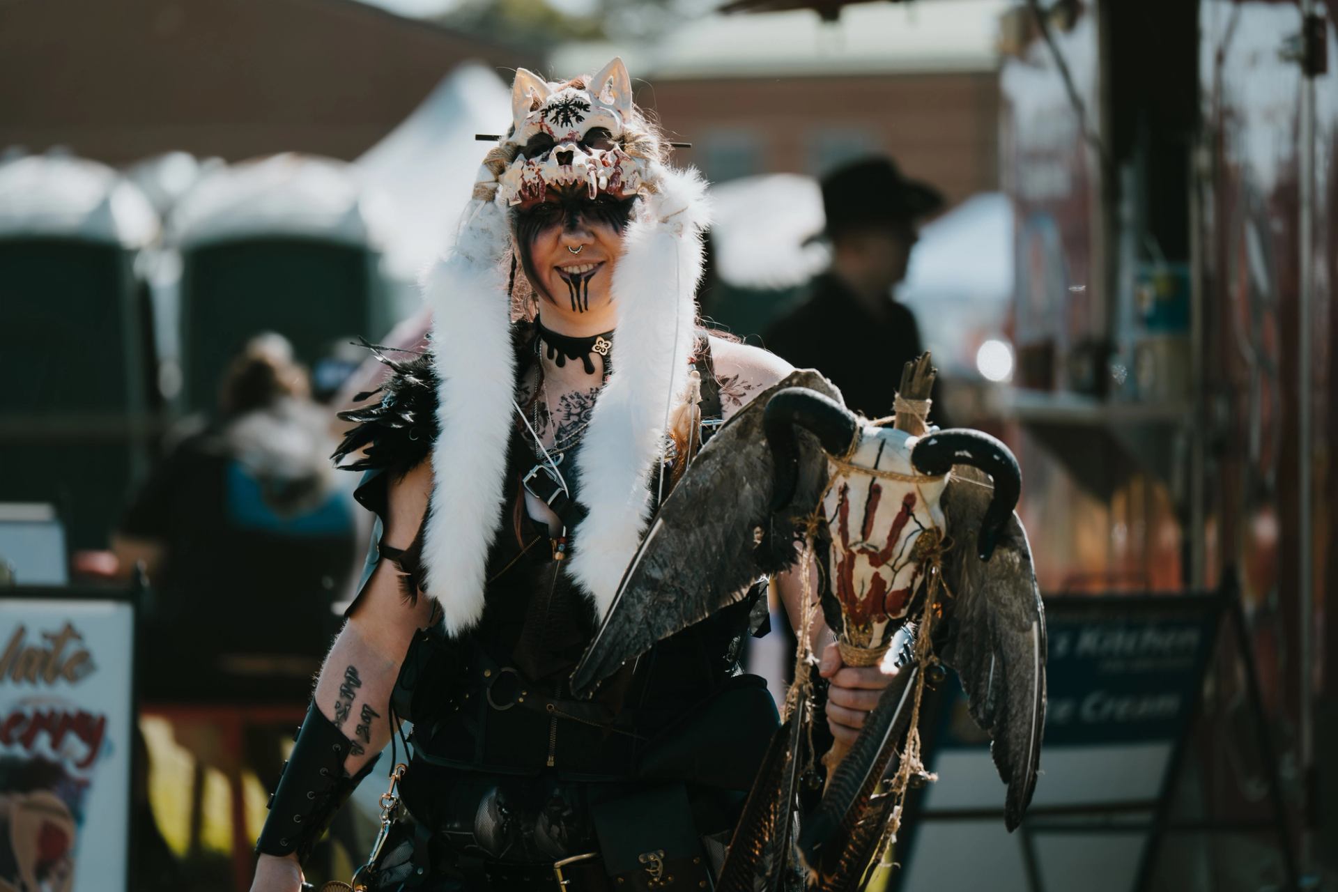 Festival participant in elaborate fantasy-style costume holding a prop weapon at a medieval-themed event.