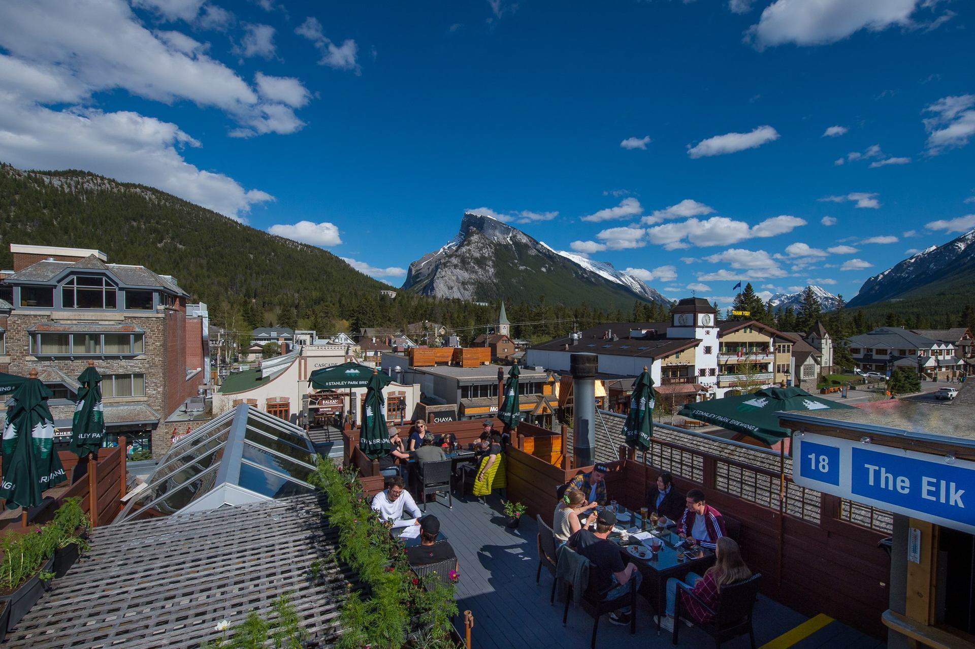 Rooftop patio at Elk & Oarsman with mountain views and guests dining.