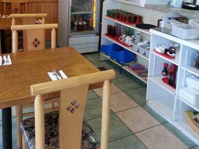 Wooden tables and shelves with condiments inside The New Mr. Spud Café
