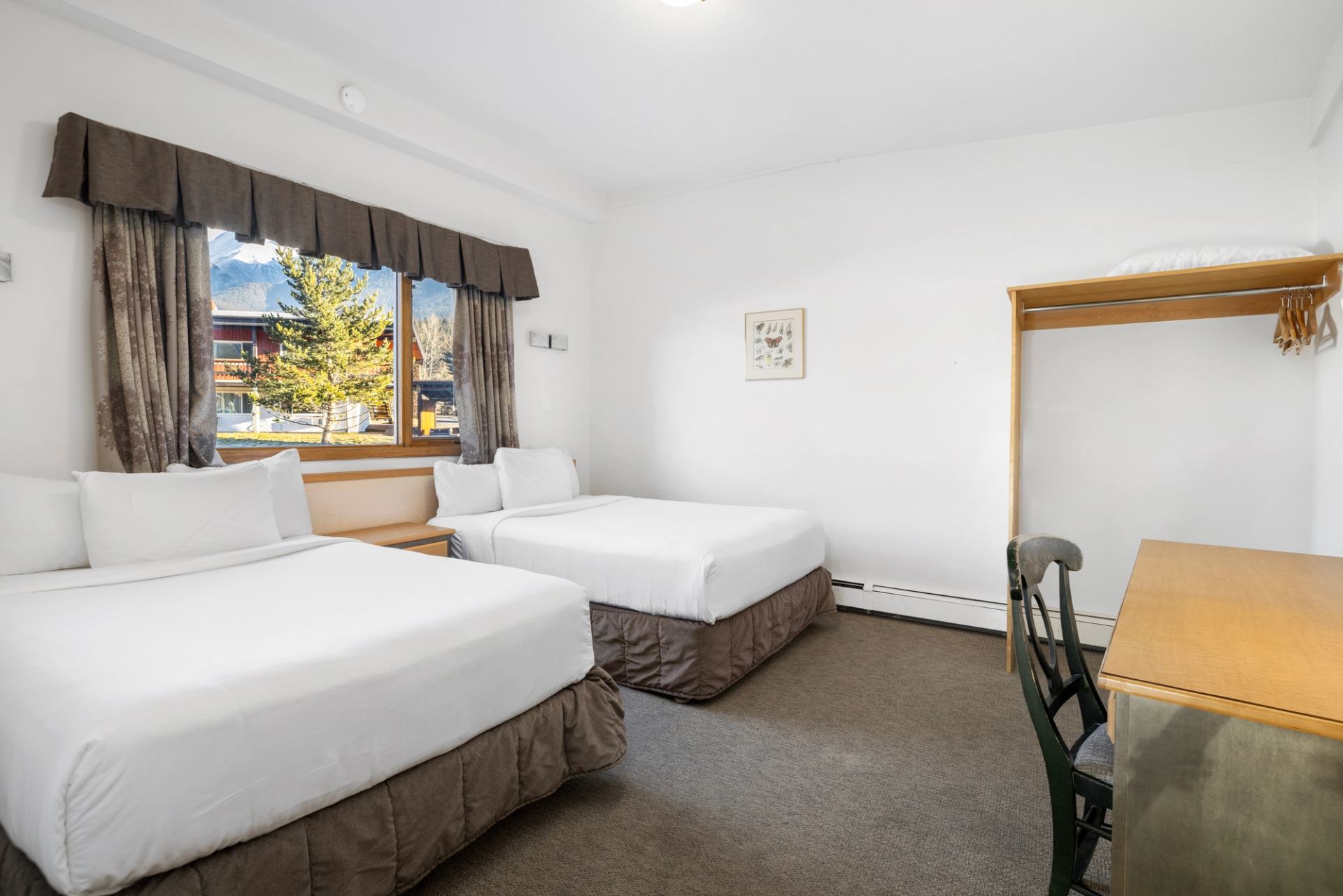 Cozy lodge room with mountain view and two beds.