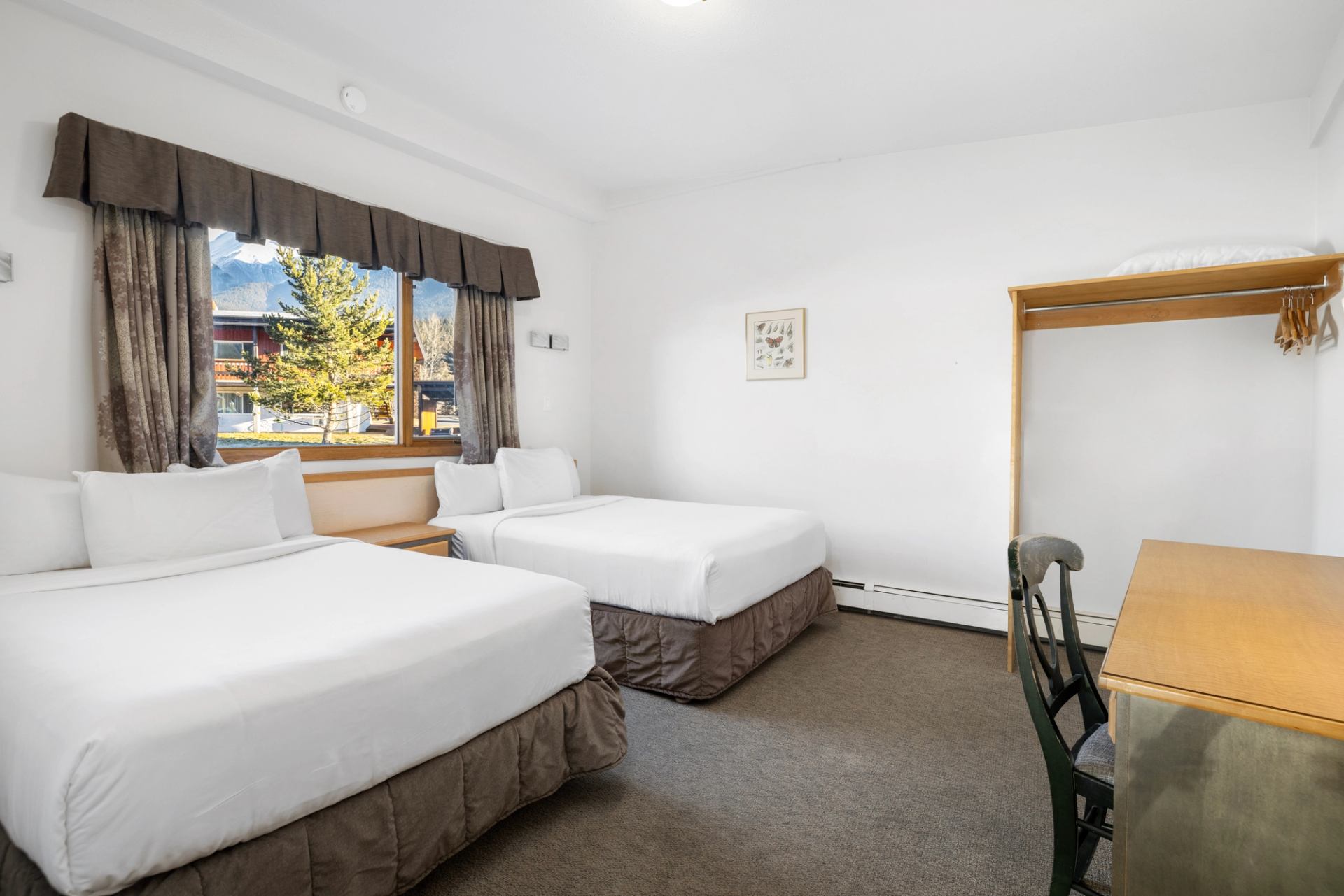 Cozy lodge room with mountain view and two beds.
