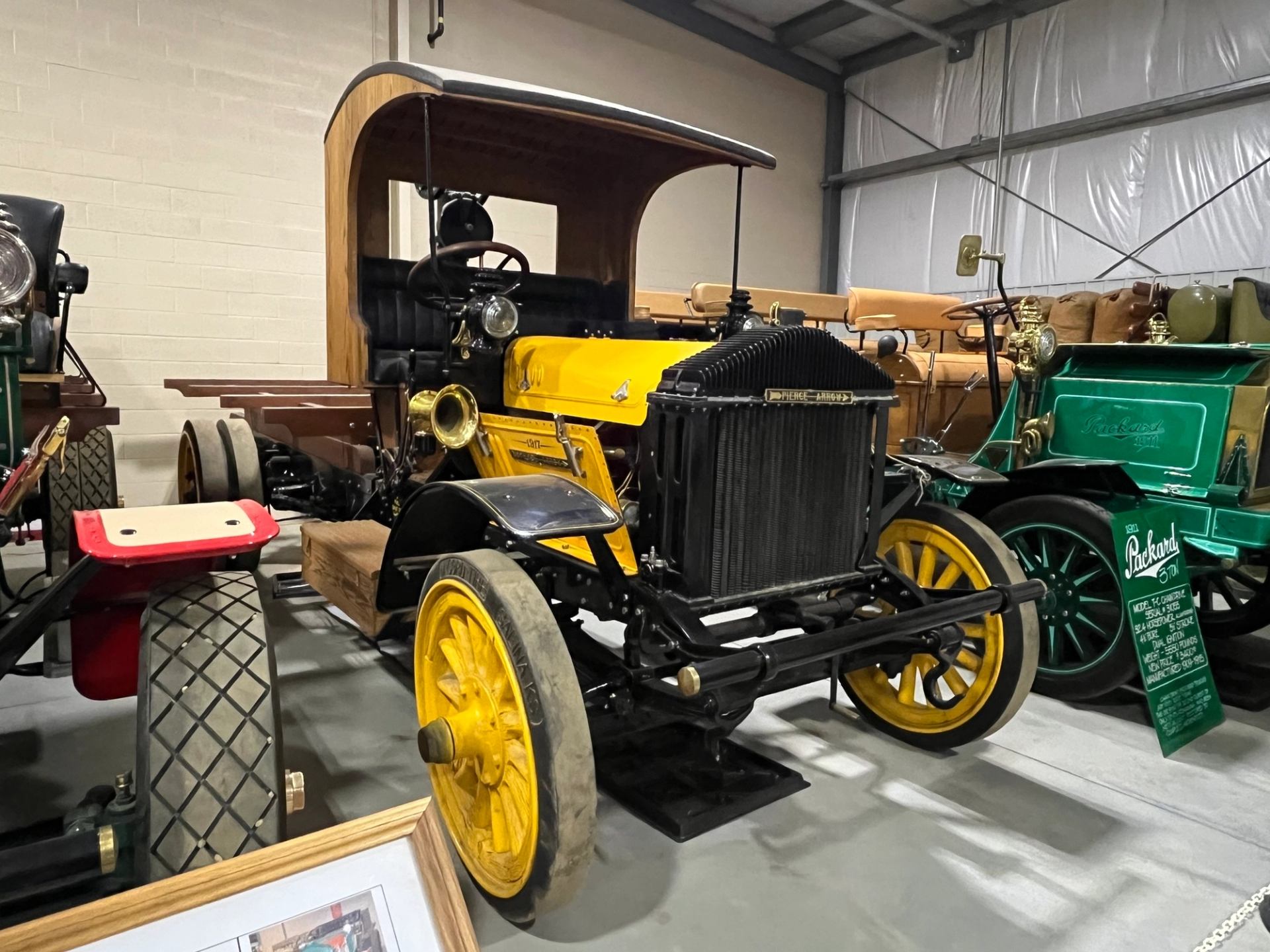 A yellow Peirce Arrow truck with solid rubber tires.