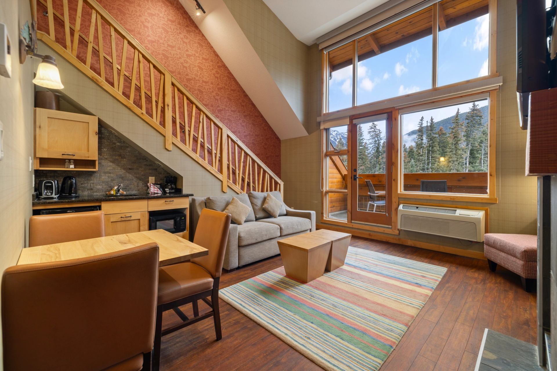 Fox Hotel suite with kitchenette, dining area, and beautiful views of the trees and mountains..