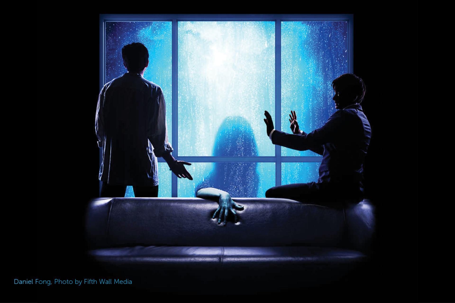 Two people react to a mysterious figure outside a rain-lit window in The Brothers Paranormal.