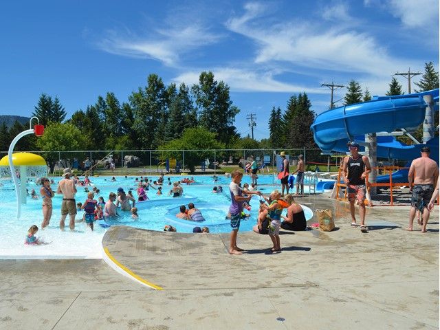 People enjoying the pool on a bright sunny day.